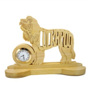 May include: A wooden desk clock in the shape of a dog, with the word "LUKAPOO" cut out of the body. The clock face is round with a gold-colored bezel. The base is shaped like a dog bone.