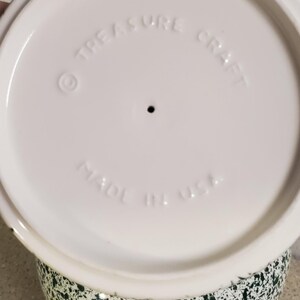 May include: A set of three ceramic mugs with a speckled, matte finish. The mugs are in shades of cream, light brown, and dark brown. Each mug has a simple, minimalist design and a rounded handle.