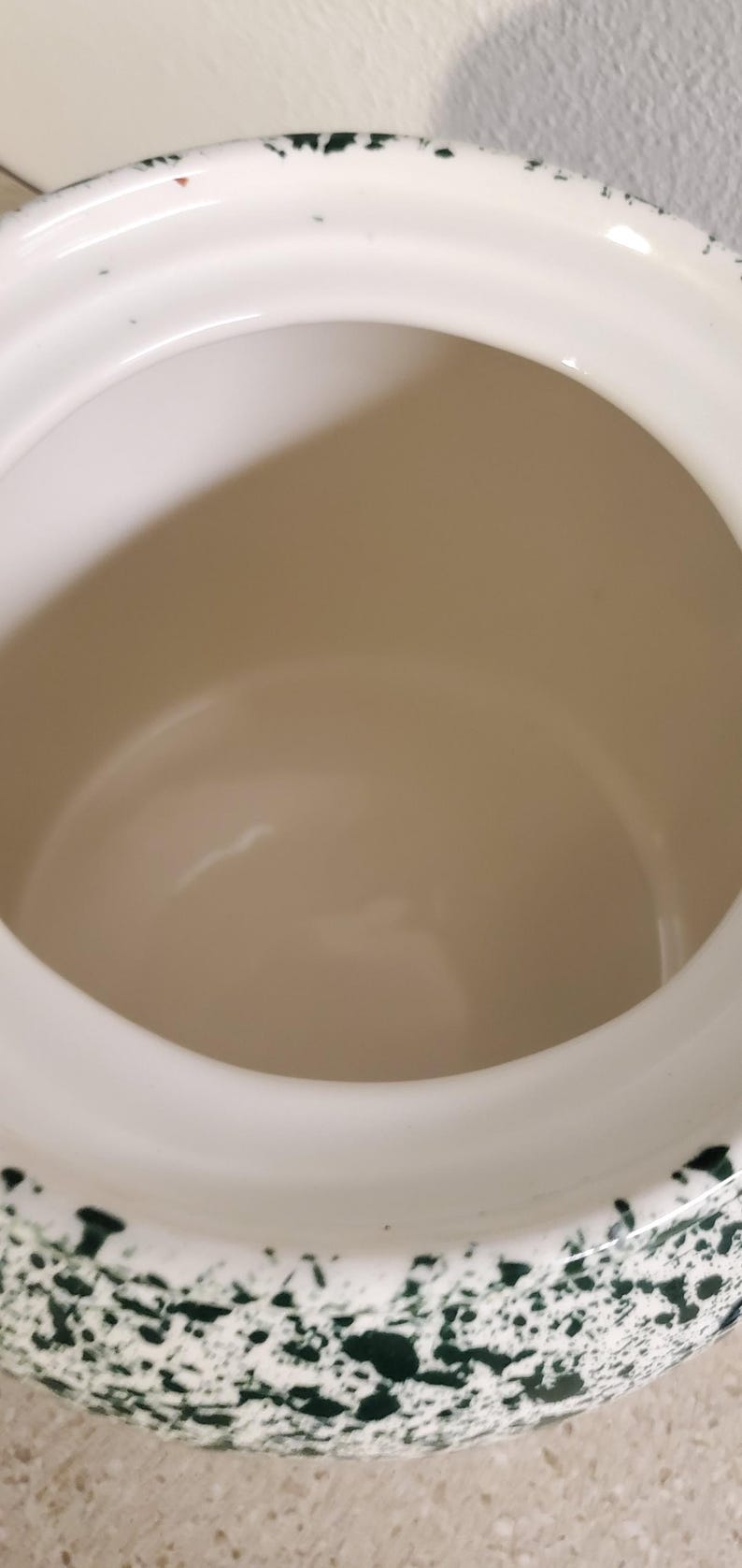 May include: A white ceramic mug with a black handle and the text "But First, Coffee" in a bold, black font. The mug is set against a blurred background, suggesting a cozy setting.