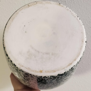 May include: A set of three ceramic mugs with a speckled, matte finish. The mugs are in shades of cream, light gray, and dark gray. Each mug has a simple, minimalist design and a rounded handle.