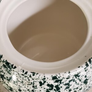 May include: A white ceramic mug with a black handle and the text "But First, Coffee" in a bold, black font. The mug is sitting on a wooden surface. The mug is approximately 4 inches tall.