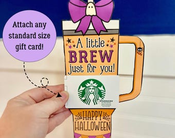 May include: A Halloween-themed gift card holder shaped like a coffee cup. The orange cup has the text "A little BREW just for you!" and "HAPPY HALLOWEEN." A purple bow and ghost adorn the top. A Starbucks gift card is inserted.