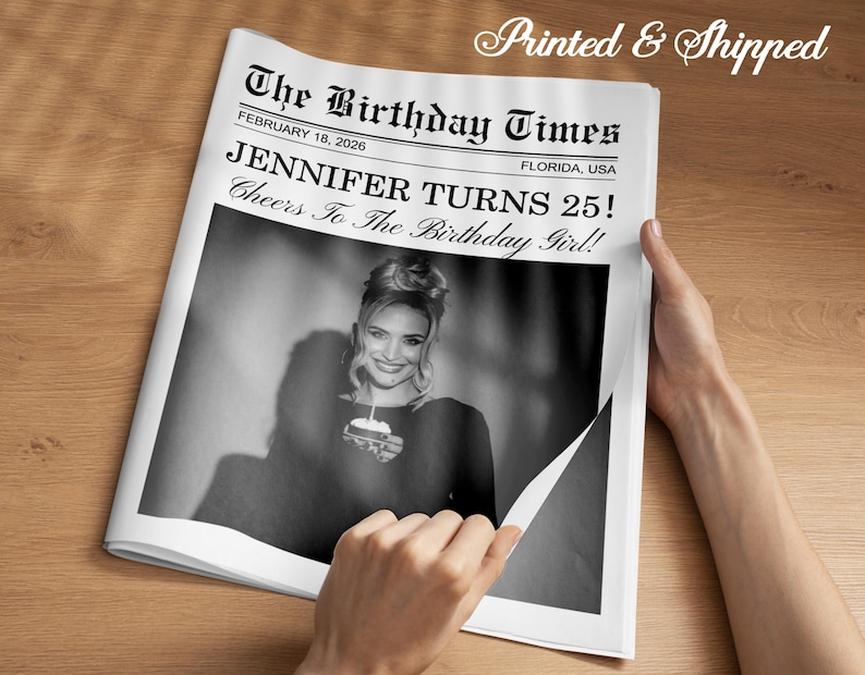 May include: A black and white newspaper-style print with the headline "The Birthday Times" and the text "JENNIFER TURNS 25!" The image features a photo of a woman holding a small cake. The words "Printed & Shipped" are at the top.