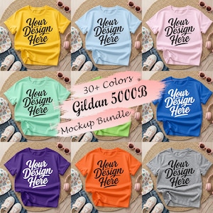 May include: A collection of short-sleeved t-shirts in yellow, light blue, pink, mint green, bright blue, purple, orange, and gray, each featuring the black text Your Design Here. A central graphic displays 30+ Colors Gildan 5000B Mockup Bundle.