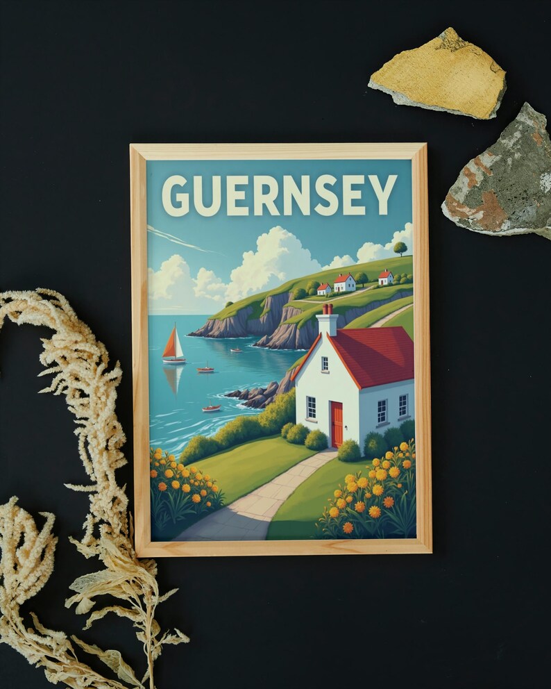 May include: Wooden framed print featuring a coastal scene with the word "GUERNSEY" at the top. The artwork depicts a white cottage with a red roof, a sailboat, and a winding path along a green hillside. Yellow flowers line the path.
