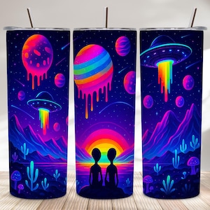May include: Three tall, cylindrical tumblers with a vibrant, psychedelic design. The artwork features a colorful sunset, mountains, planets, and UFOs with rainbow beams. The tumblers have a stainless steel straw and lid.