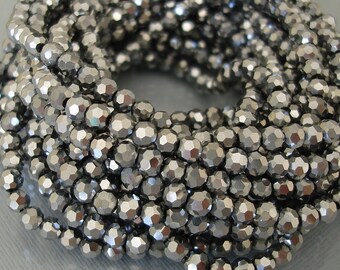May include: A strand of silver-toned faceted beads. The beads are round and have a metallic finish.