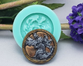 May include: A silicone mold for making resin or polymer clay buttons. The mold features a detailed design of an angel with wings and a plant. The mold is shown with a finished button made from the mold.