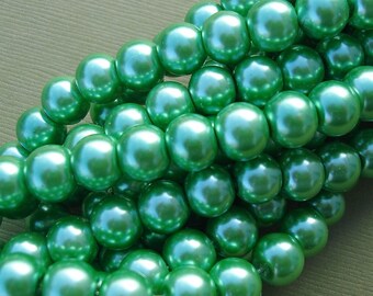 May include: A strand of round, green pearl beads. The beads have a smooth, glossy finish.