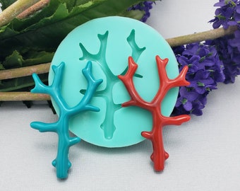 May include: Two silicone molds for making coral-shaped resin crafts. One mold is filled with a turquoise blue coral, and the other mold is filled with a red coral.