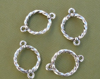 May include: Four silver-toned twisted wire jump rings with two small loops on each ring. The rings are approximately 1 inch in diameter.