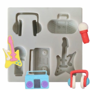 Pode incluir: Forma de silicone para fazer decorações de bolo. A forma tem oito desenhos diferentes: uma guitarra, um microfone, um rádio, fones de ouvido, um microfone, uma guitarra, um rádio e fones de ouvido.