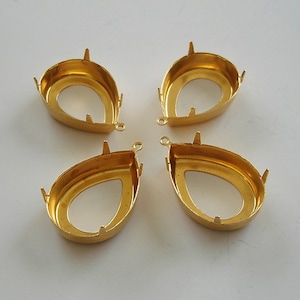 以下が含まれることがあります： 4つの金色の涙型のジュエリーセッティング。各セッティングには、隆起したベゼル、4つの爪、チェーンなどを取り付けるための小さなループがあります。セッティングは空で、石をセットする準備ができています。