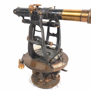Könnte beinhalten: Antikes Vermessungsinstrument aus Messing und Schwarz mit einem Teleskop und einer runden Basis.