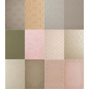 May include: A collection of textured paper sheets in various colors, including beige, pink, and green. Each sheet features a different embossed pattern, such as floral designs, feathers, and ornate borders. The papers are arranged in a grid.