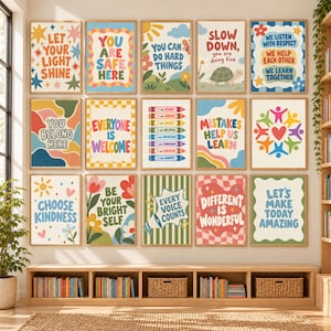 Könnte beinhalten: Eine Sammlung von fünfzehn rechteckigen Wandbildern mit farbenfroher, retro-inspirierter Typografie und Illustrationen mit positiven Affirmationen wie Let Your Light Shine, You Are Safe Here und Mistakes Help Us Learn, alle in hellem Holz gerahmt.