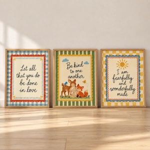 May include: Three framed wall art prints with light-colored backgrounds and scalloped borders. The left print features blue gingham and the text Let all that you do be done in love. The center print shows a deer, fox, and rabbit with the text Be kind to one another. The right print has yellow gingham, a sun, and the text I am fearfully and wonderfully made.