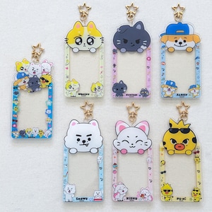 May include: Seven rectangular acrylic photo card holders with gold star-shaped clasps. Each frame features colorful cartoon animal characters, including Wonchu, Hoxstar, Jakey, Snowe, Kishu, and Pu-Ni, with printed names and small icons.