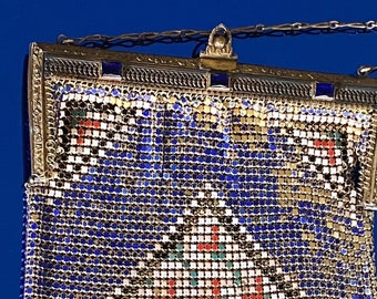 May include: A blue and silver mesh purse with a geometric pattern and a silver chain strap.