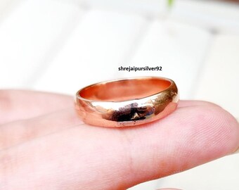 May include: A rose gold ring with a hammered texture. The ring is displayed on a person's hand. The text "shrejaipursilver92" is visible in the background.