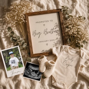 May include: A wooden frame with the text Promoted to Big Brother January 202X, a photo of a child, an ultrasound scan, a pair of cream knit baby booties, and a cream baby bodysuit with the text Baby Cooper, all decorated with dried flowers.