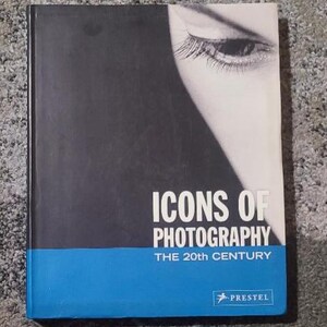 May include: A hardcover book titled "ICONS OF PHOTOGRAPHY THE 20TH CENTURY" with a black and white image of an eye on the cover. The book has a blue band at the bottom and the publisher's logo.