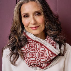 May include: A knitted cowl scarf featuring a two-tone pattern of deep red and light grey. The accessory has a ribbed knit texture along the top and bottom edges, with a repeating geometric motif across the centre section of the fabric.