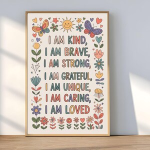 Könnte beinhalten: Ein gerahmter Kunstdruck mit beigem Hintergrund und farbenfrohem Text mit der Aufschrift "I AM KIND, I AM BRAVE, I AM STRONG, I AM GRATEFUL, I AM UNIQUE, I AM CARING, I AM LOVED." Der Druck ist mit Schmetterlingen, Blumen und Herzen verziert.