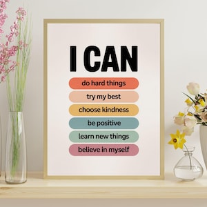 Op de afbeelding: Een ingelijste print met de woorden "I CAN" in vette zwarte letters. Daaronder staan kleurrijke horizontale balken met motiverende zinnen: "do hard things", "try my best", "choose kindness", "be positive", "learn new things" en "believe in myself".
