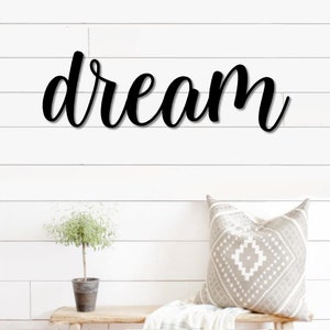 May include: Black metal wall decor with the word "dream" in a cursive font.