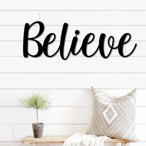 May include: Black metal wall decor with the word "Believe" in a cursive font.