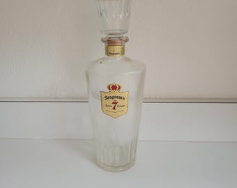 To zabytkowy karafka do whisky Seagram's Seven Crown z przezroczystego szkła z korkiem.