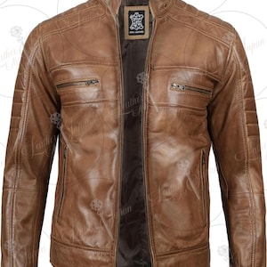 Könnte beinhalten: Braune Lederjacke mit Stehkragen und mehreren Reißverschlusstaschen. Die Jacke hat eine Steppung an den Schultern und einen Frontreißverschluss. Das Etikett in der Jacke lautet "REAL LEATHER". Der Produktcode "LN-009" ist sichtbar.