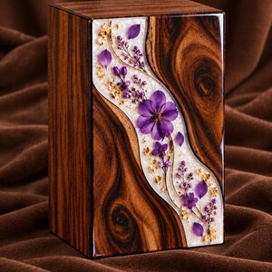 May include: A rectangular wooden urn featuring a polished dark brown wood grain finish. A central, curved inlay of white resin runs vertically, embedded with pressed purple flowers, delicate sprigs of lavender, and small gold-colored flakes.