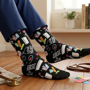 May include: Black socks with a nurse theme, featuring medical supplies and the words "Love Nurse" and "Nurse a Vong". A stethoscope, bandages, and a small bottle labeled "Wellness" are on the wooden floor.