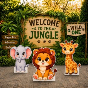 May include: A large wooden sign reading Welcome to the Jungle with a smaller sign reading Wild One, accompanied by three cartoon animal cutouts: a gray elephant, an orange lion, and a yellow giraffe, all set against a lush green outdoor background.
