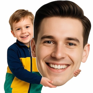May include: A large cutout of a smiling man's face is held by a young child. The child is wearing a blue, yellow, and green jacket. The man's face is a close-up with a bright smile and dark hair.