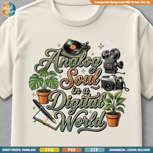 May include: Cream-colored t-shirt featuring a graphic design with the text "Analog Soul in a Digital World." The design includes a record player, film camera, and potted plants. The shirt has a crew neck and short sleeves.