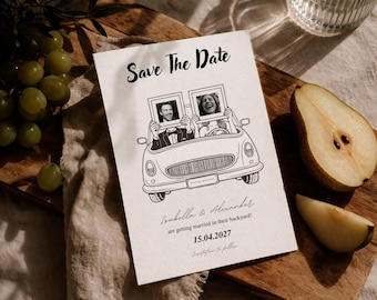 Könnte beinhalten: Cremefarbene "Save The Date"-Karte mit einer schwarzen Strichzeichnung eines Autos, das ein Paar mit gerahmten Fotos transportiert. Die Karte enthält die Namen "Isabella & Alexander" und das Datum "15.04.2027". Die Karte liegt auf einem Holzbrett.