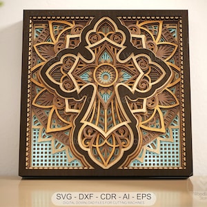 Op de afbeelding: Een gelaagd houten kunstwerk met een kruisontwerp. Het kunstwerk gebruikt tinten bruin, beige en lichtblauw. Het ontwerp bevat gedetailleerde patronen en vormen. De tekst "SVG - DXF - CDR - AI - EPS" is zichtbaar aan de onderkant.