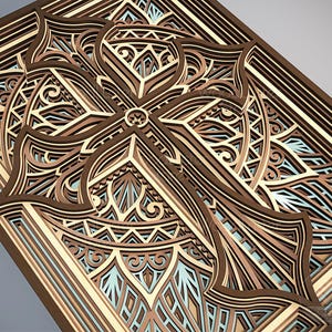 Puede incluir: Una obra de arte de madera en capas con un dise&ntilde;o de cruz detallado. La obra utiliza varios tonos de marr&oacute;n, beige y azul claro, creando un efecto tridimensional. Se ven patrones intrincados y formas geom&eacute;tricas.