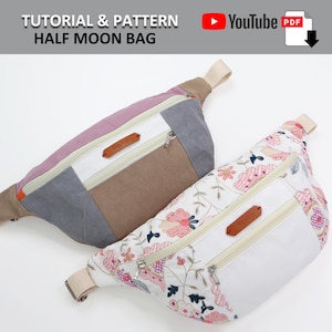 May include: Two half-moon shaped bags. One is made of a patchwork of pink, gray, and brown fabric. The other is white with a floral pattern and a brown leather zipper pull. Both bags have a zipper closure and a strap.