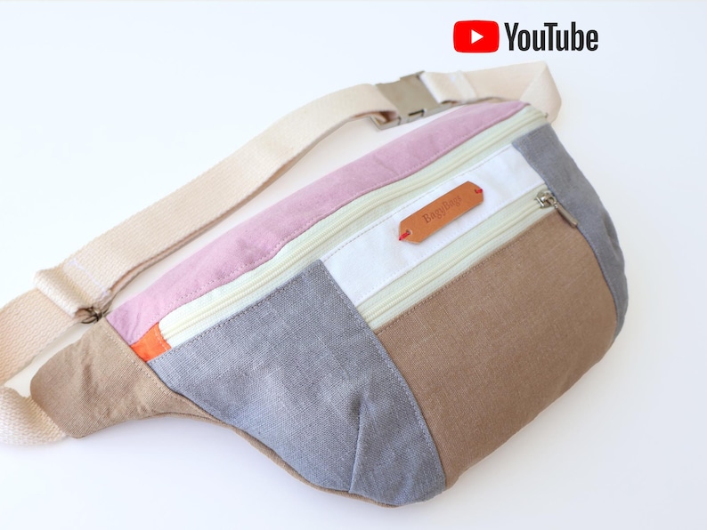 May include: A multi-colored fabric fanny pack with a zippered pocket and a brown leather label that says "Bagtique".