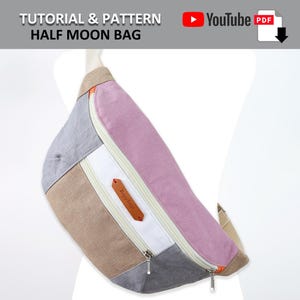 May include: A half moon bag made of fabric in shades of gray, beige, white, and pink. The bag has a zipper closure and a small leather label with the word "Baguette" on it.