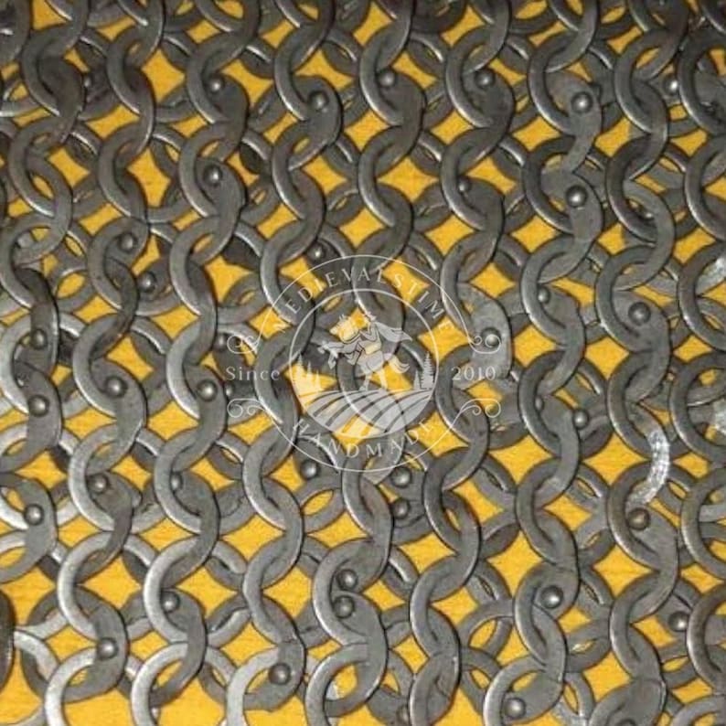 May include: Close-up of chainmail armour, showing a dense pattern of interlocking metal rings. The background is yellow. A watermark with text and a crest is visible in the image.
