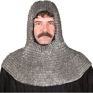 May include: A silver chainmail coif, a hood and neck covering made of interlocking metal rings. The coif is worn over a black garment. The hood frames the face of a person with a moustache.
