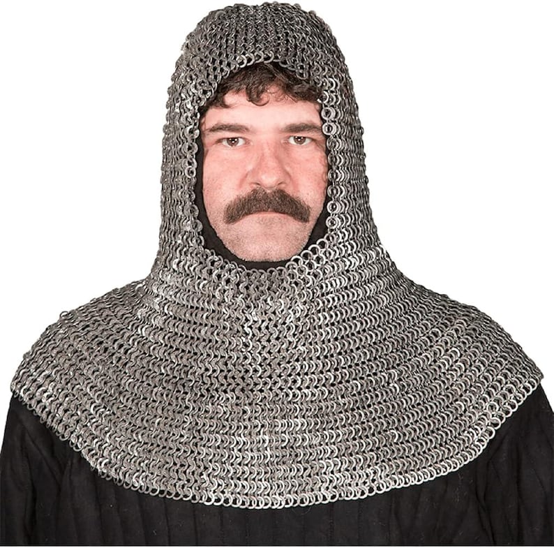 May include: A silver chainmail coif, a hood and neck covering made of interlocking metal rings. The coif is worn over a black garment. The hood frames the face of a person with a moustache.