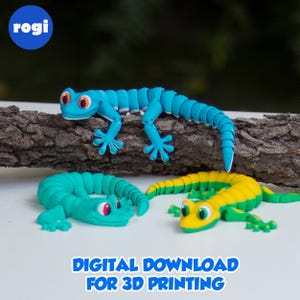 Puede incluir: Tres figuras de lagartos articulados de colores azul, verde y amarillo. Los lagartos tienen ojos rojos y están colocados sobre una superficie blanca con un tronco en el fondo. El texto en la parte inferior dice "DESCARGA DIGITAL PARA IMPRESIÓN 3D."