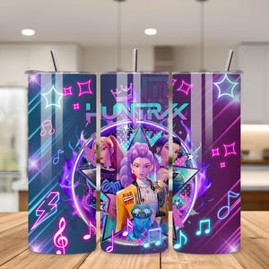 May include: A set of three stainless steel tumblers with lids and straws. Each tumbler features a vibrant design with the word "HUNTRAX" and illustrations of animated characters, musical notes, and geometric shapes in shades of purple, blue, and pink.