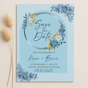 Puede incluir: Una invitación de boda azul claro con detalles florales. El texto "Save the Date" se muestra en una elegante escritura, rodeado por una corona floral. La invitación incluye los nombres "Kevin + Becca" y la fecha 09.13.2025.